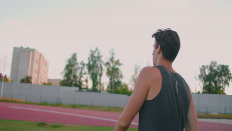 A-javelin-Thrower-walks-around-the-stadium-with-spears-and-collects-them.-Go-with-a-spear-in-hand-against-the-background-of-the-stadium-stands.-The-training-of-the-Olympic-champion.